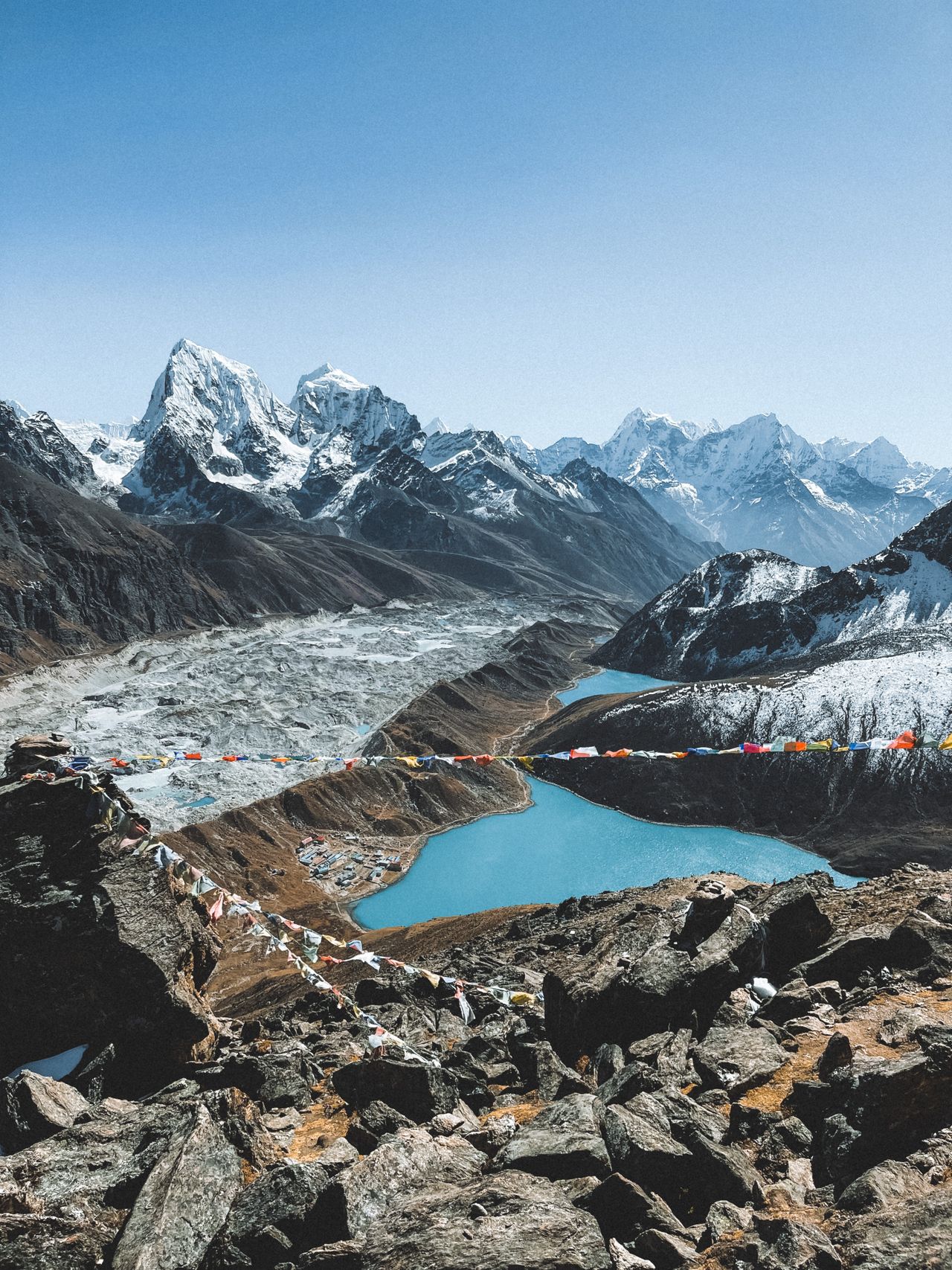 Turquoise glacial lakes above Gokyo, prayer flags strung across the ridge